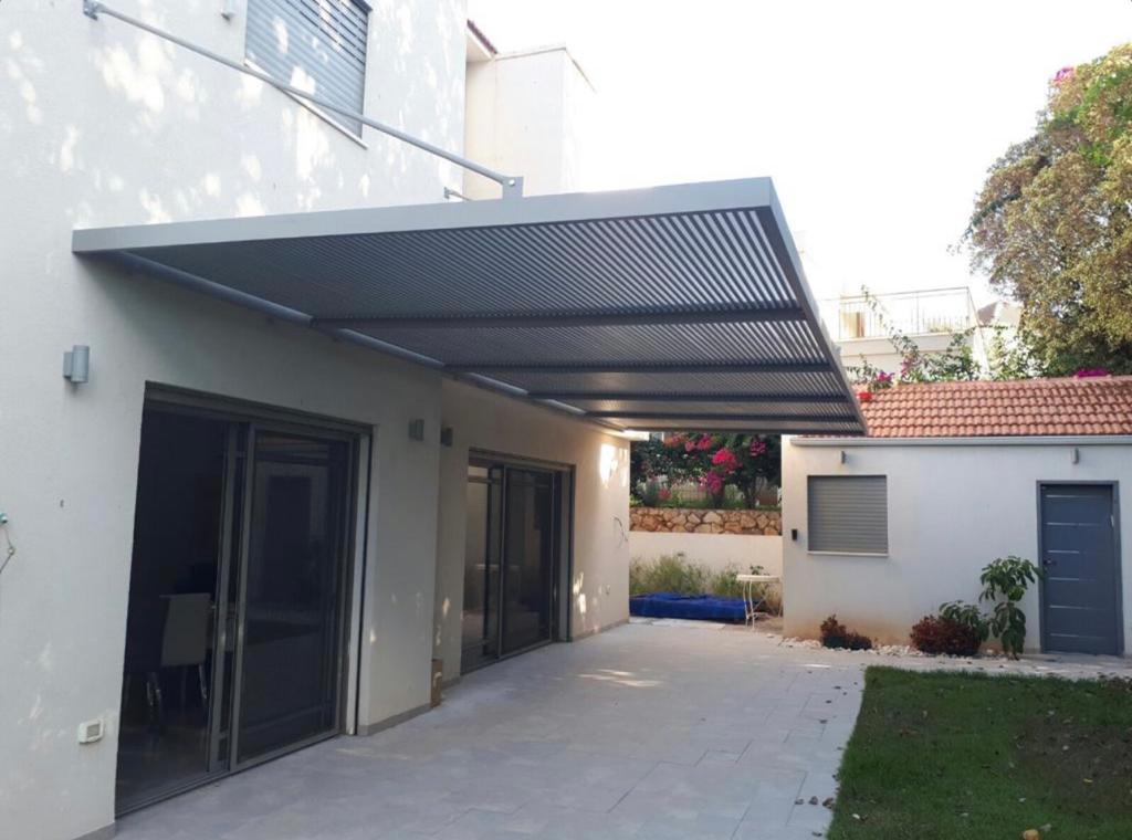 פרגולת רפפות אלומיניום אנתרציט מעל פטיו צמוד לבית