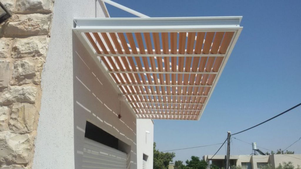 פרגולת קונזול צמודת קיר עם רפפות בגוון עץ, בלי עמודים