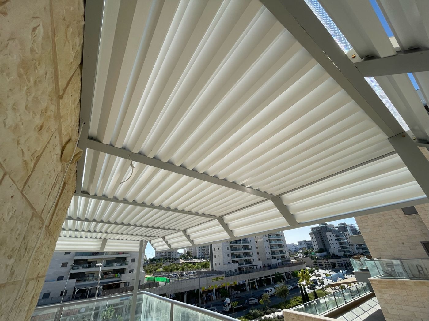 מרפסת דירה מוצללת בפרגולת אלומיניום בחריש