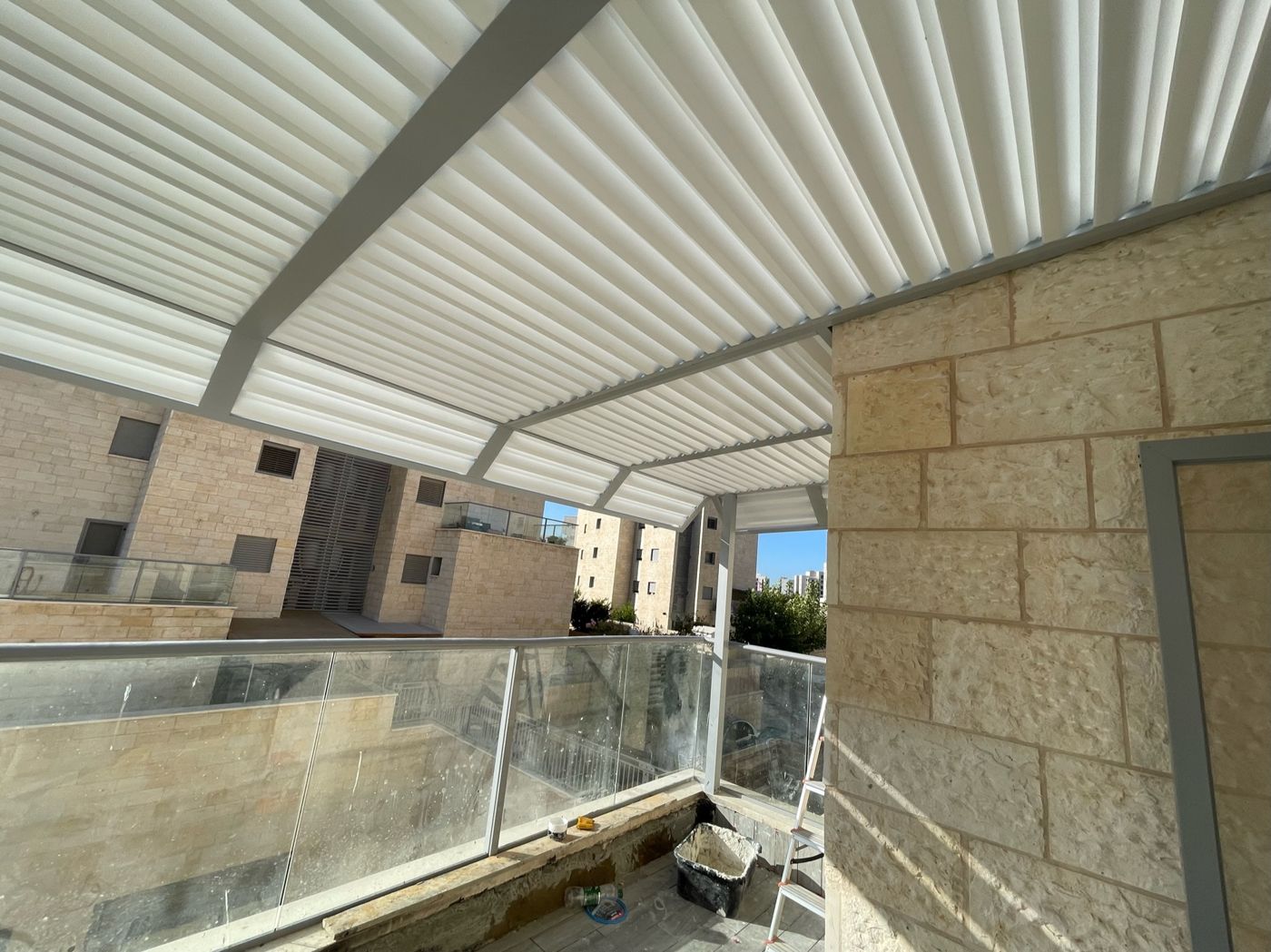 קירוי אלומיניום בהיר מעל מרפסת דירה בחריש