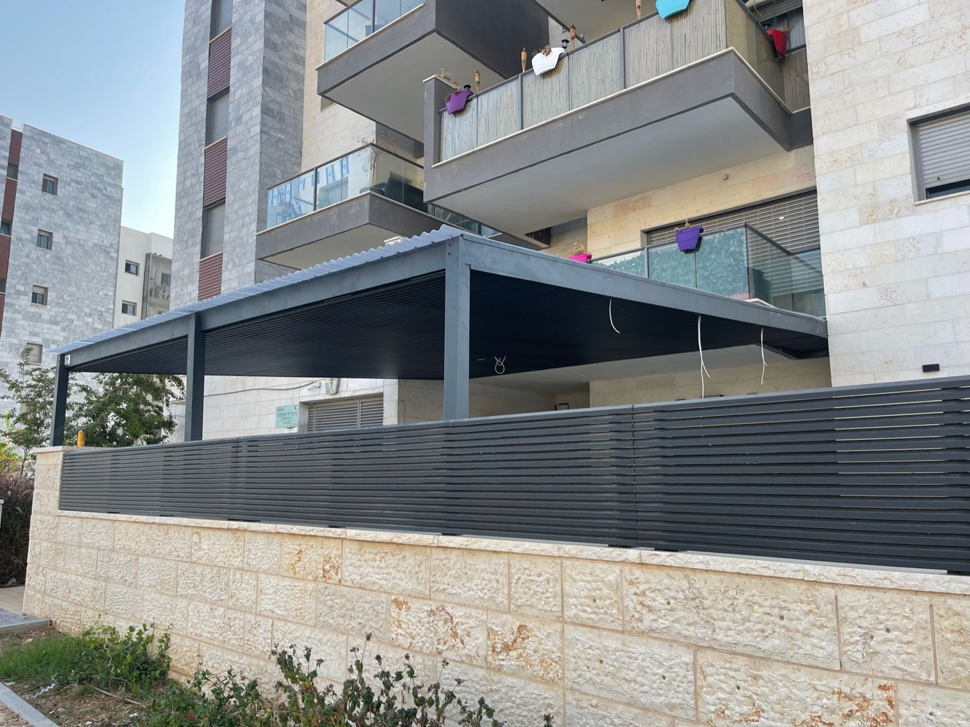 פרגולת אלומיניום כהה עם מסתור רפפות בחצר בחריש