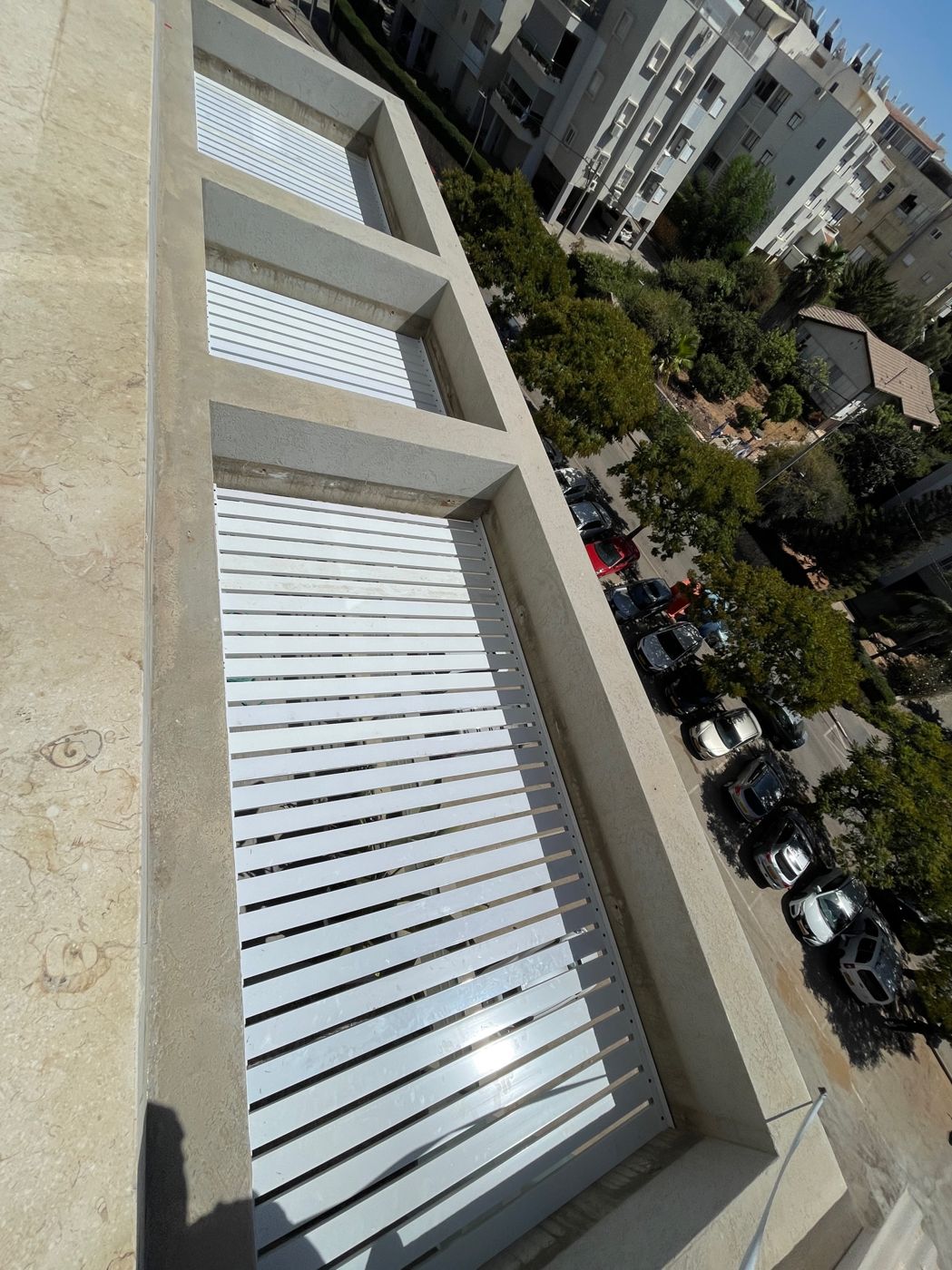 מסתורי רפפות אלומיניום לבנים בחזית בניין בהרצליה
