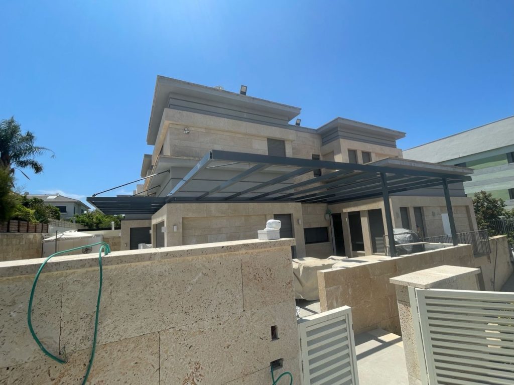 מבט צד על פרגולת אלומיניום כהה בבית פרטי בהוד השרון