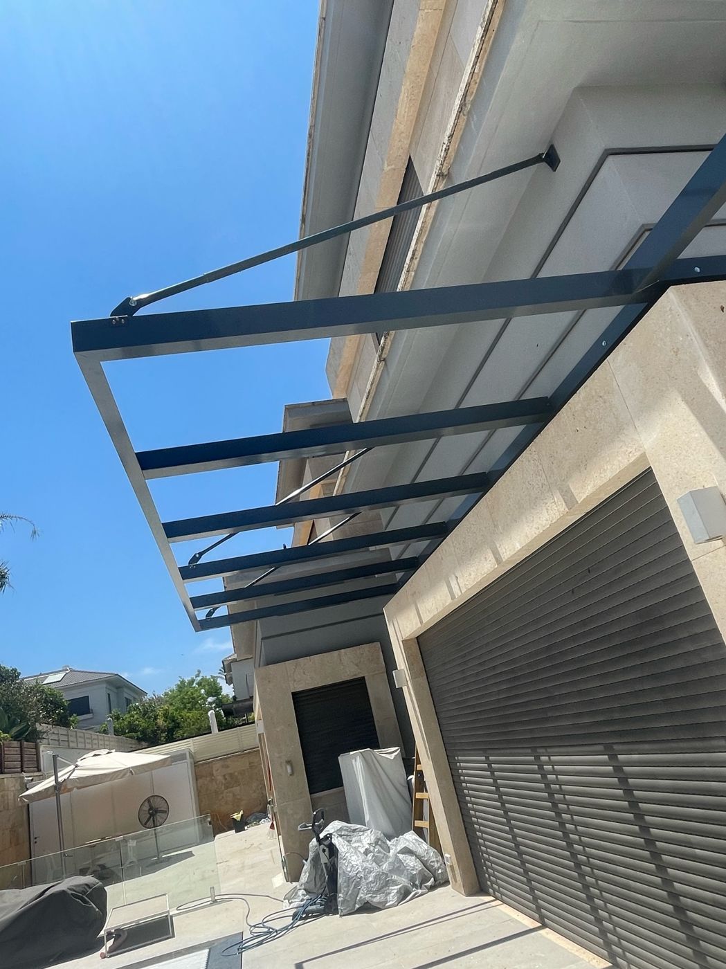 פרגולת אלומיניום כהה מעל חניה בבית פרטי בהוד השרון