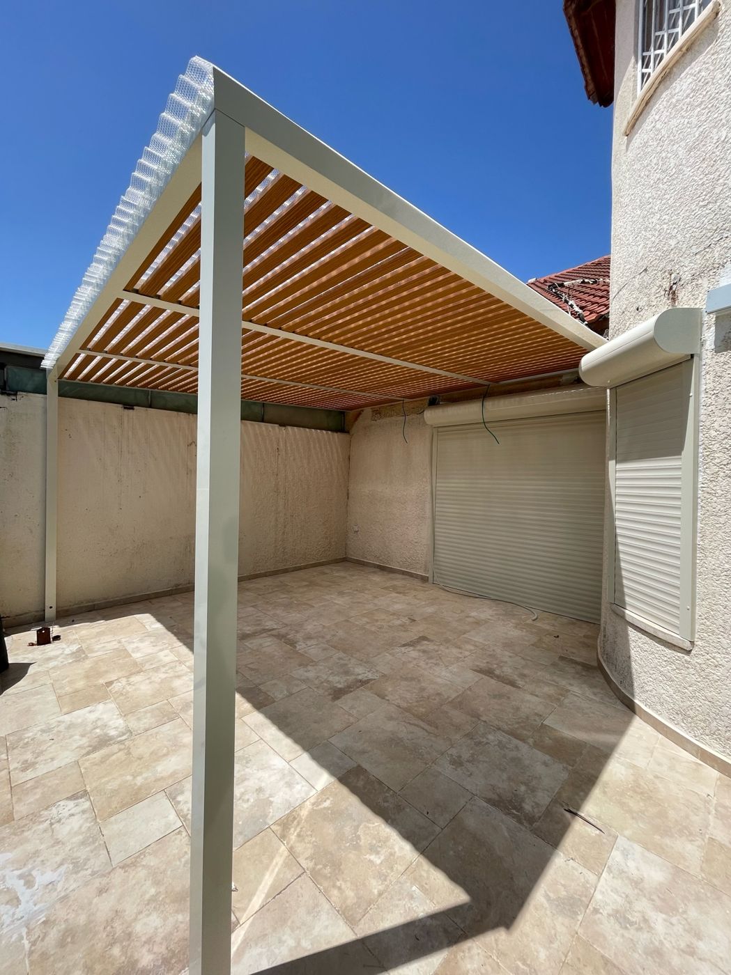 מבנה פרגולת אלומיניום עם עמוד לבן בחצר בראש העין