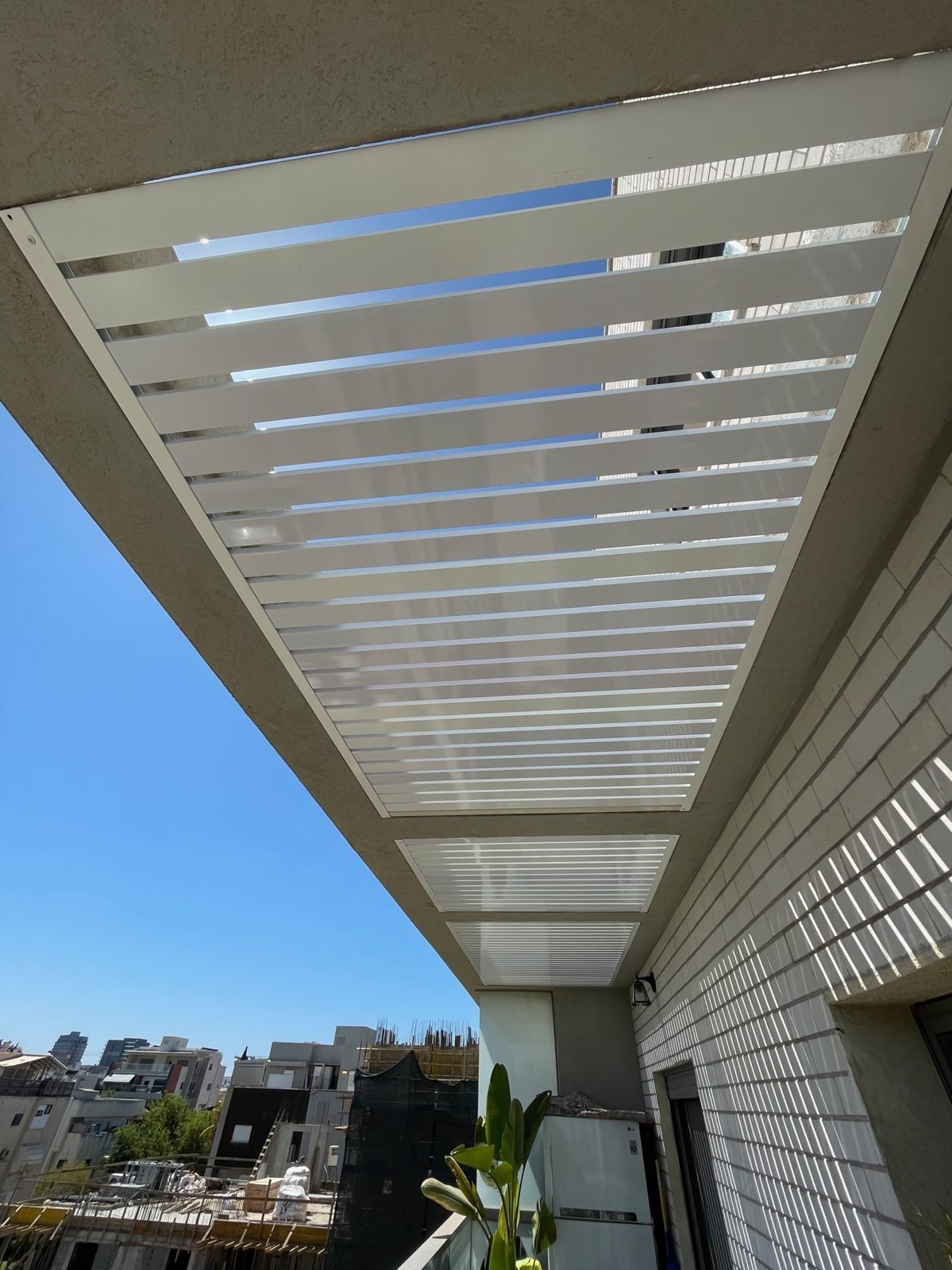 פרגולת אלומיניום לבנה עם נוף העיר מרפסת בהרצליה