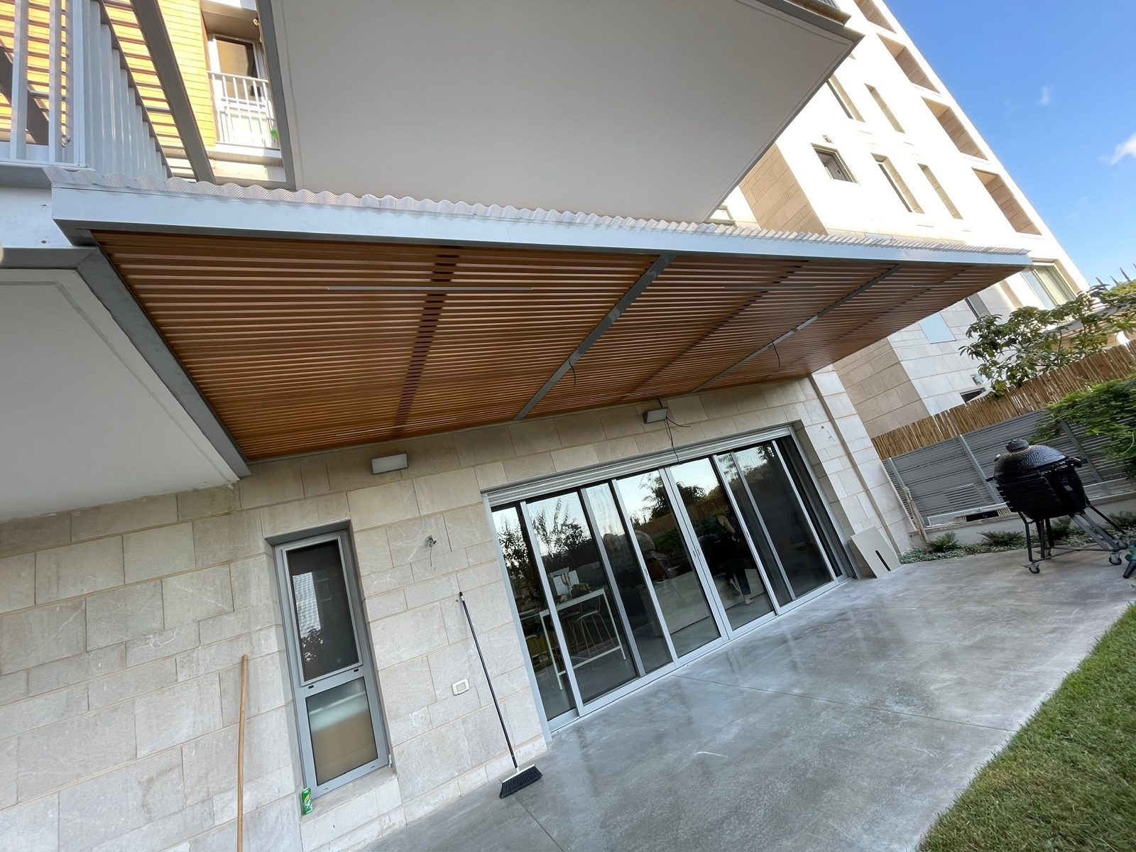 פרגולת אלומיניום בגוון עץ בחזית בית מודרני בהרצליה