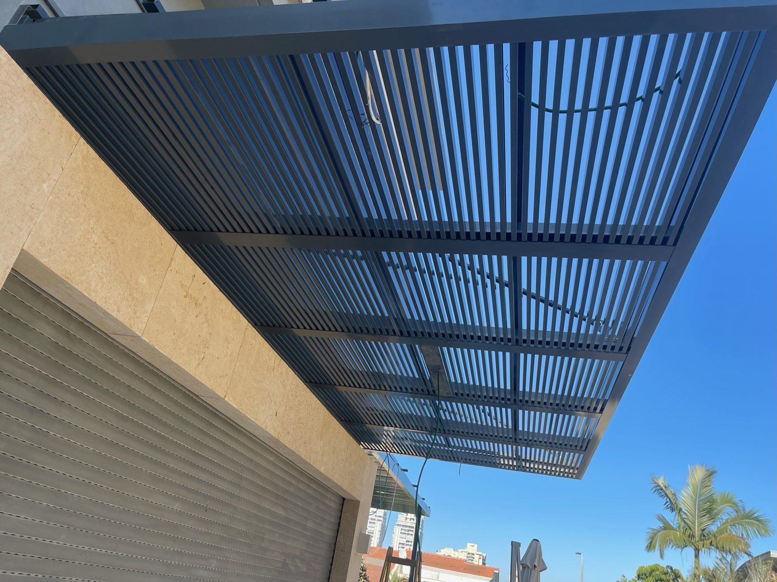 רפפות אלומיניום כהות של פרגולה, מבט מלמטה, בהוד השרון