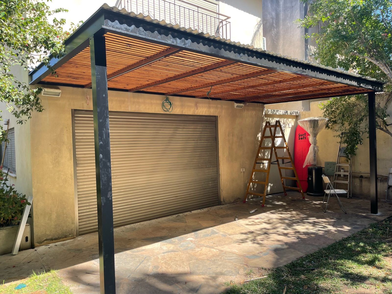 פרגולת אלומיניום עם רפפות בגוון עץ בחזית בית פרטי ברעננה